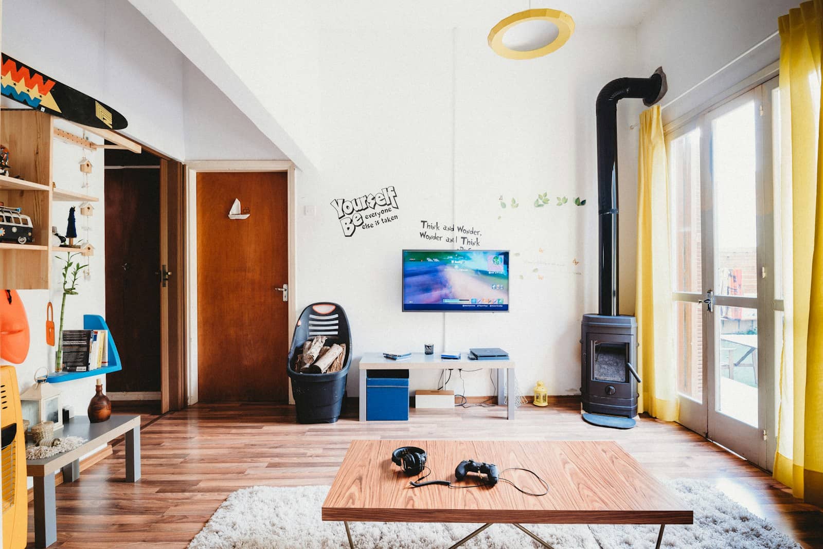 A living room gaming setup with a wall-mounted screen and controller