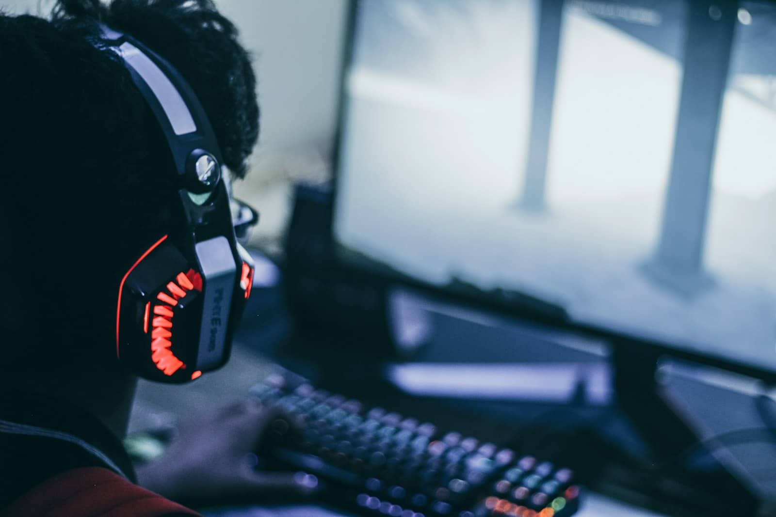 A person wearing a gaming headset at a PC