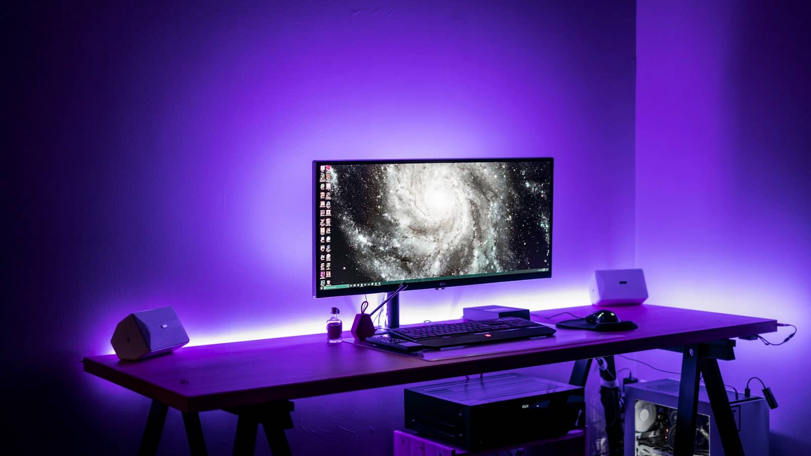 A gaming desk setup with an ultrawide monitor and PC