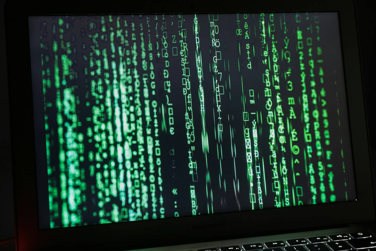 A laptop screen showing cascading green code
