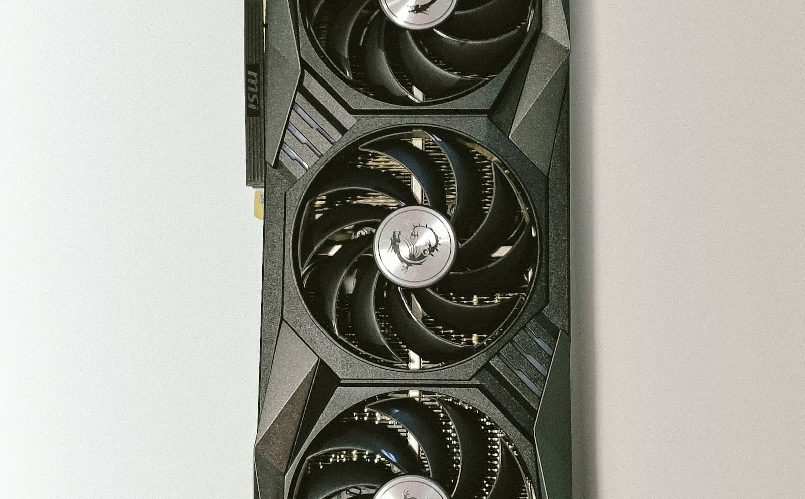 A triple-fan graphics card against a light background