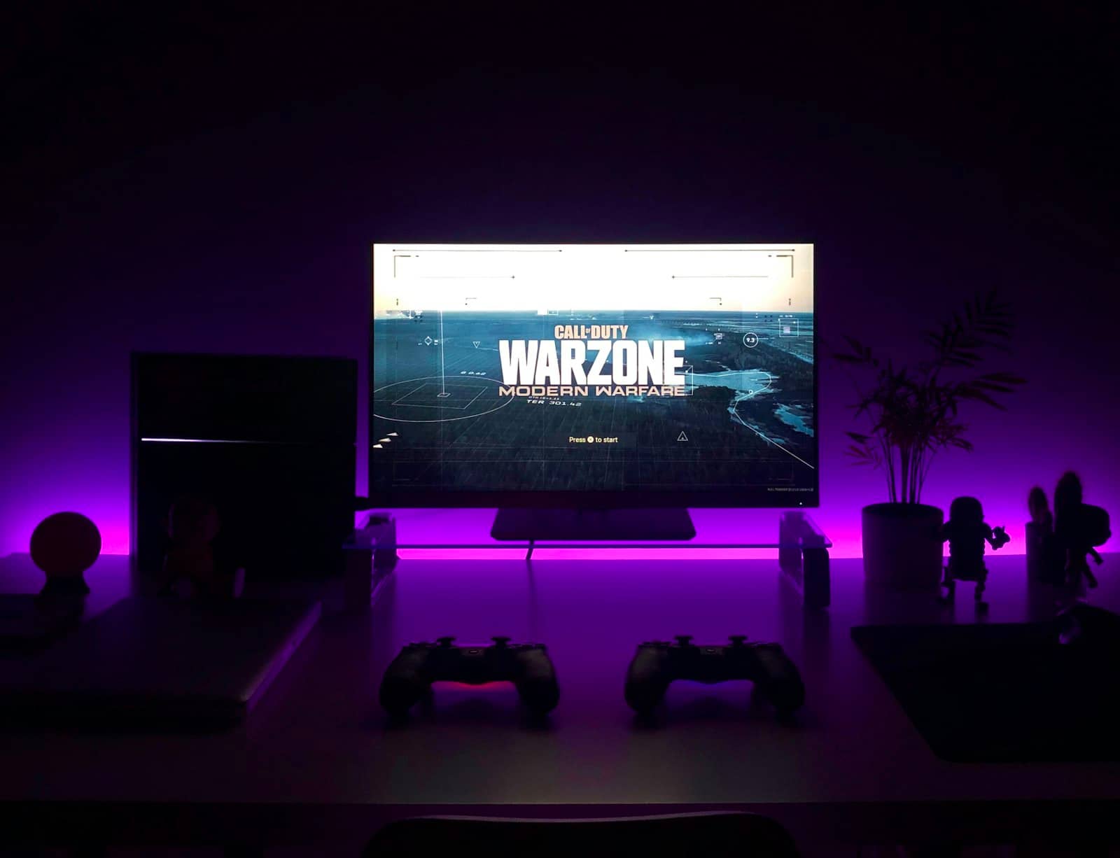 A gaming monitor glowing with purple lighting on a desk