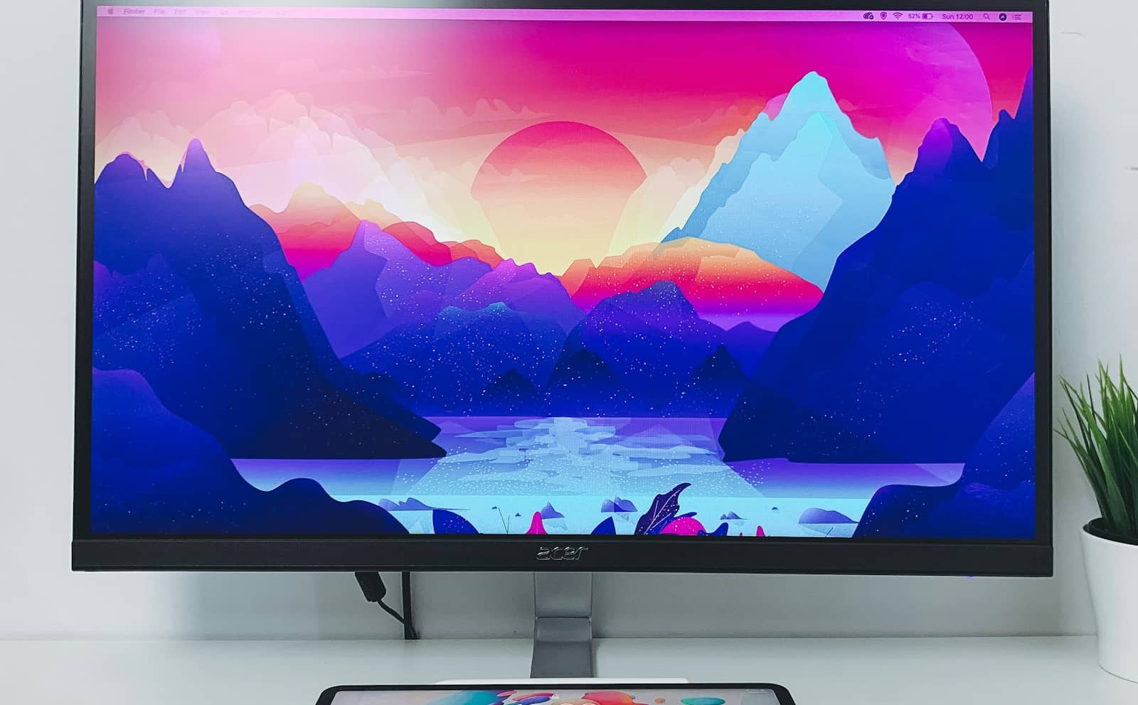 A monitor displaying a vivid colorful mountain landscape