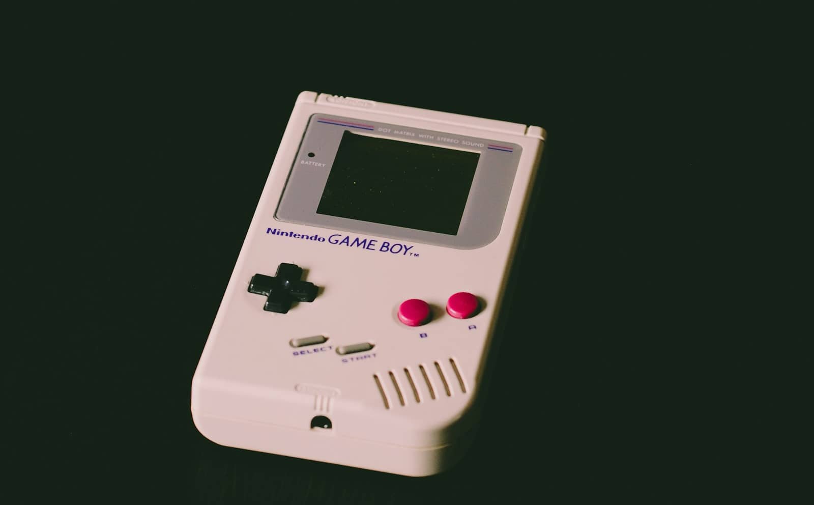 A classic handheld game console on a dark background