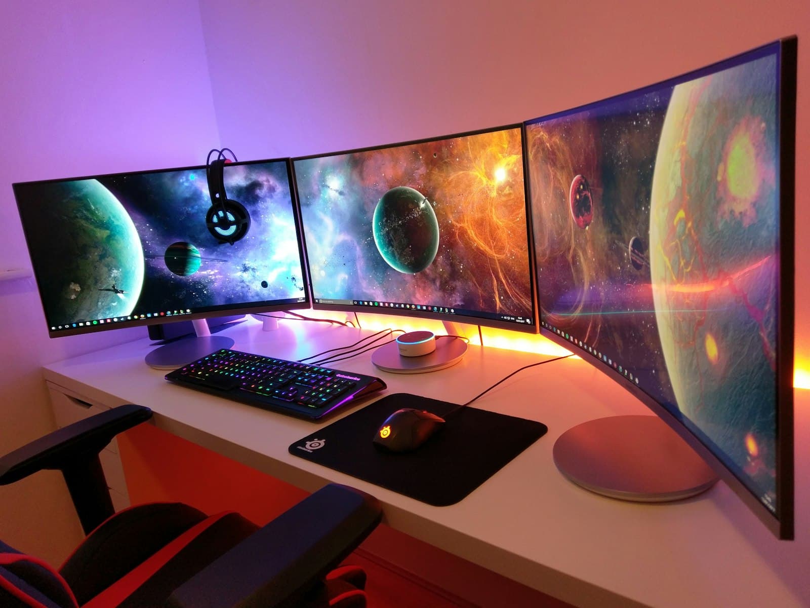 A multi-monitor gaming PC setup lit with RGB