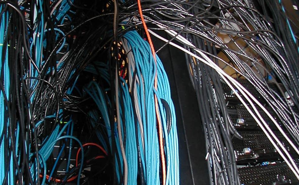 Cisco networking hardware installed in a data center rack, the category of equipment Crosswork and Secure Workload manage centrally
