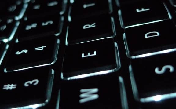 A laptop running Windows in a dim office setting at night
