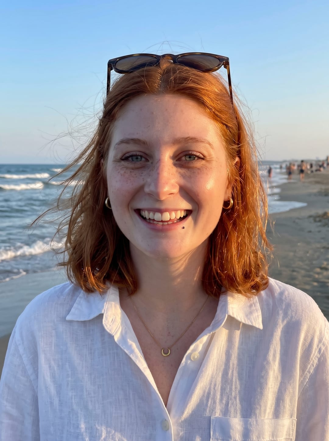 AI photo of the woman on a beach at golden hour with sunglasses on her head, wind in her hair, in a white linen shirt