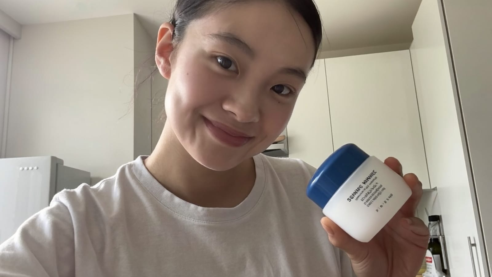 AI-generated UGC-style ad frame of a person holding a product up to the camera in natural light