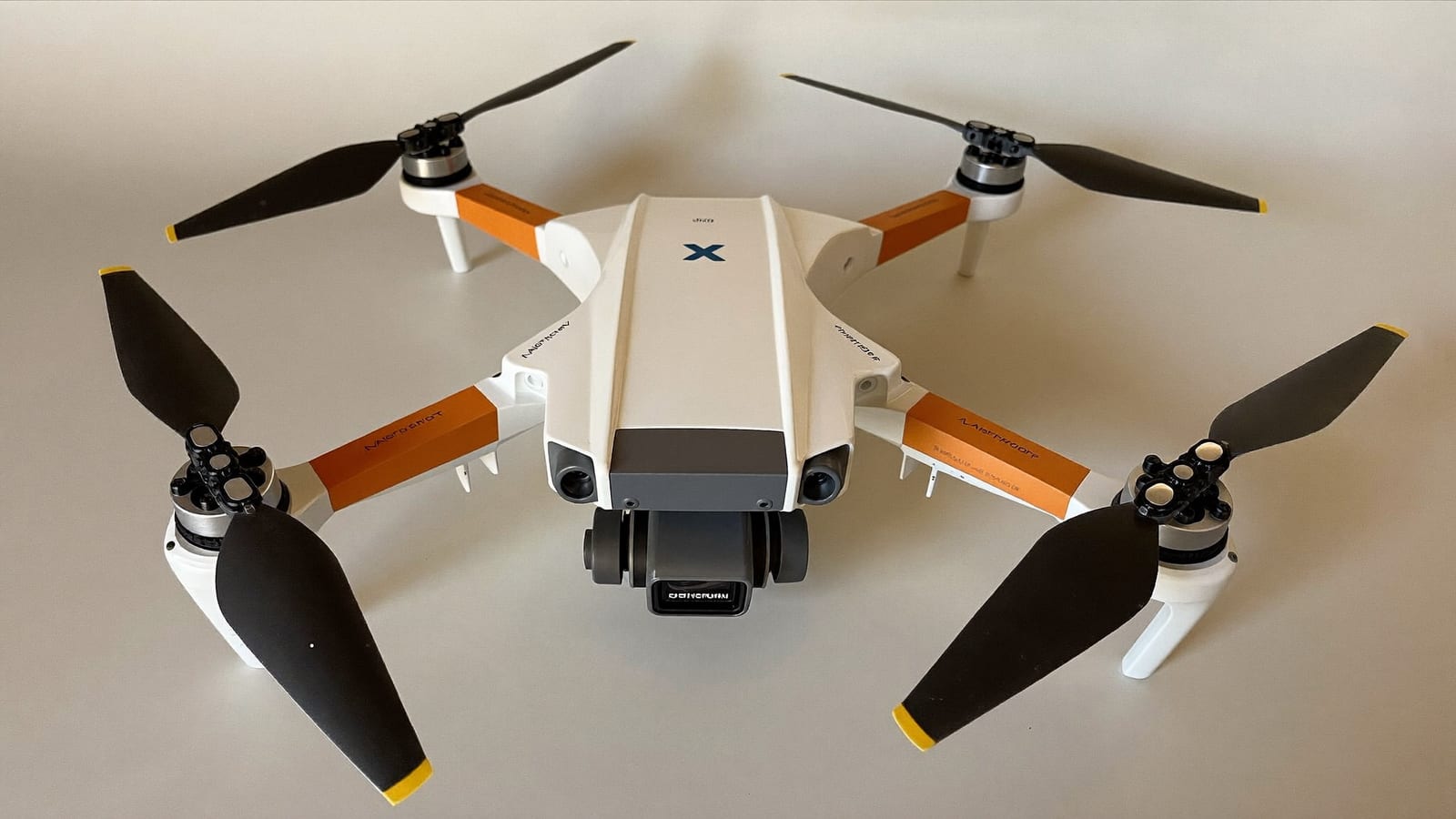 A compact beginner quadcopter drone with a camera gimbal on a table