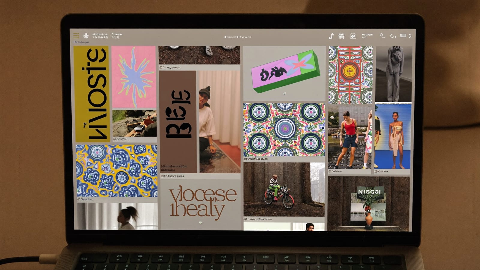 A laptop showing an abstract grid of video thumbnails across different topic categories