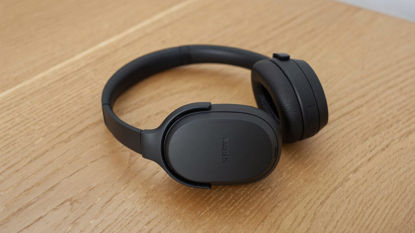 A pair of premium over-ear noise-cancelling headphones on a desk