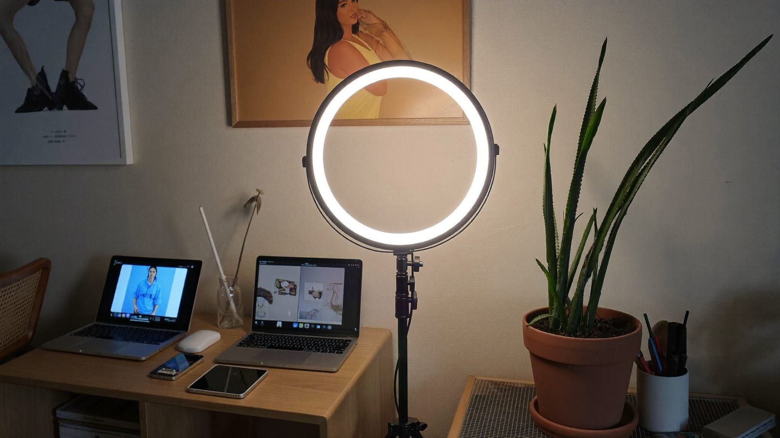 A ring light and a laptop on a cozy creator desk with a plant — the faceless-page production corner