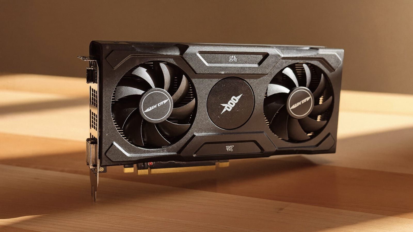A compact dual-fan graphics card on a desk — an Intel Arc B580-class budget GPU