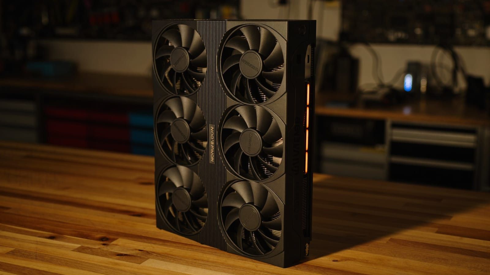 A large modern triple-fan graphics card on a clean workbench