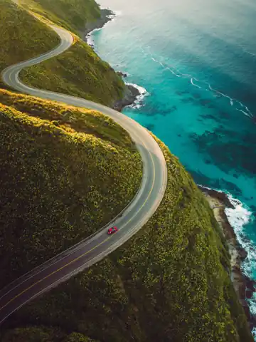 Aerial shot of a coastal road above a turquoise sea