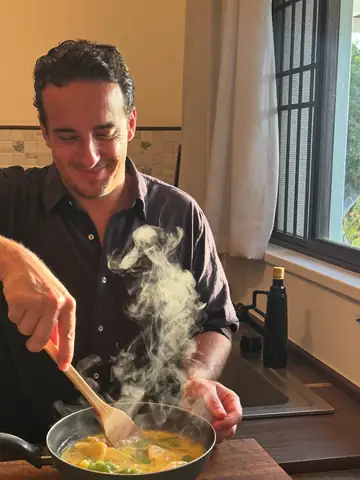 Candid photo of a man cooking in a sunlit kitchen