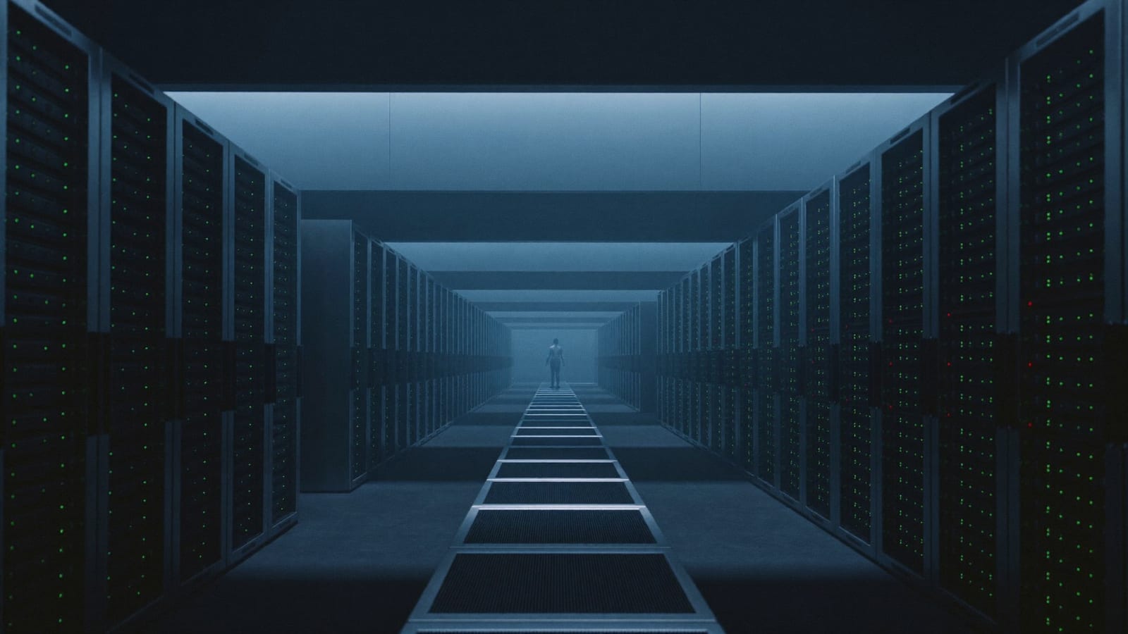 Photographic view down a long data-center aisle of glowing server racks receding into blue haze, with a lone figure walking toward the far end